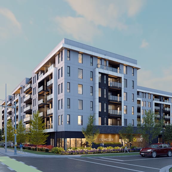 a modern apartment building with a parking lot in front.