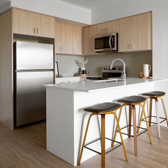 a kitchen with a white counter and wooden cabinets.