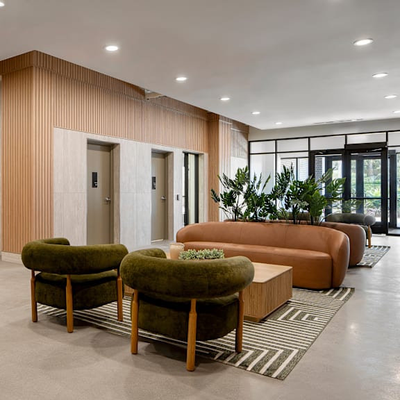 a modern living room with a green couch and a brown armchair.
