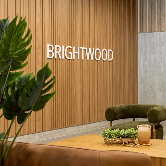 a room with a wooden table and green chairs with the word "brightwood" on the wall.