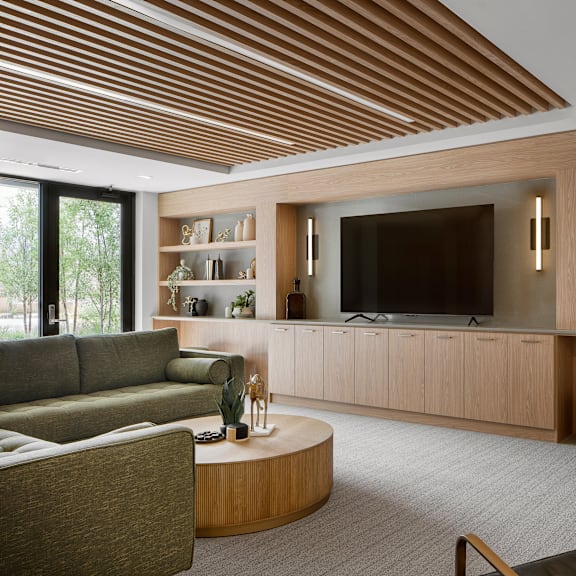 a modern living room with a large flat screen tv and a wooden ceiling.