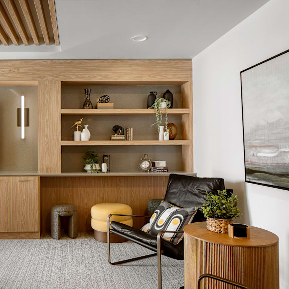 a modern living room with a black leather chair and a wooden cabinet.