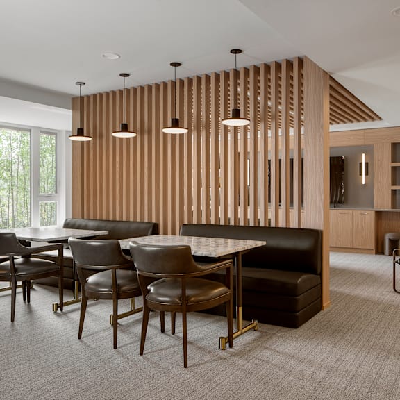 a modern dining room with a wooden partition and a black sofa.
