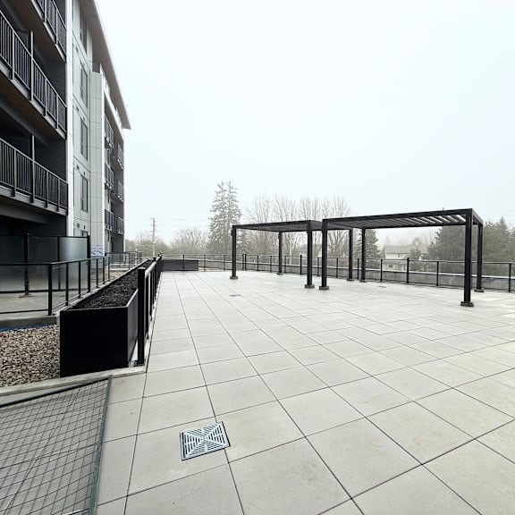a patio with a metal railing and a drain in the middle.