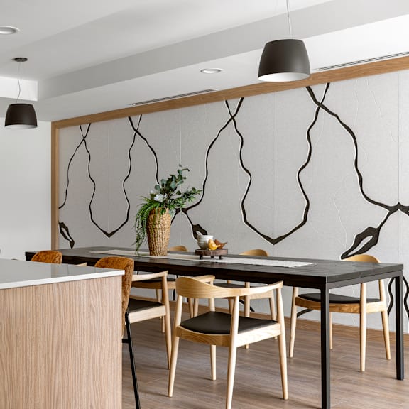 a modern dining room with a black table and wooden chairs.