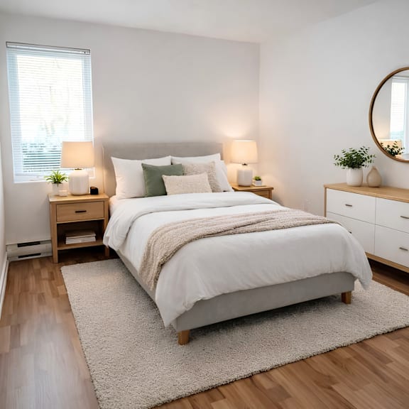 a bedroom with a large bed, a nightstand with a lamp, and a dresser with a mirror.