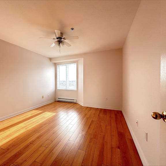 a room with wooden floors and a ceiling fan.