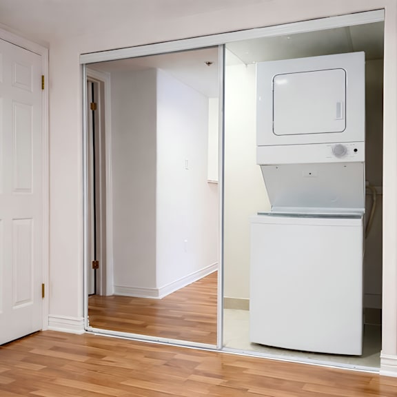a white door is open to a room with a white fridge.