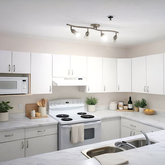a kitchen with white cabinets and a white fridge.