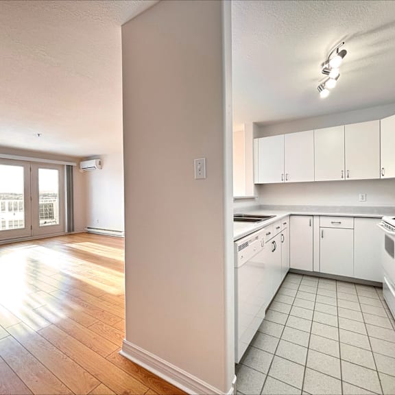 a kitchen with white cabinets and a tiled floor.
