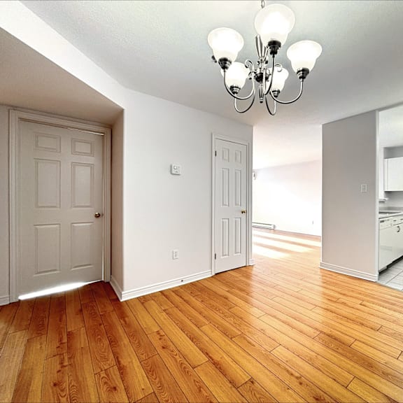 a room with wooden floors and a chandelier.