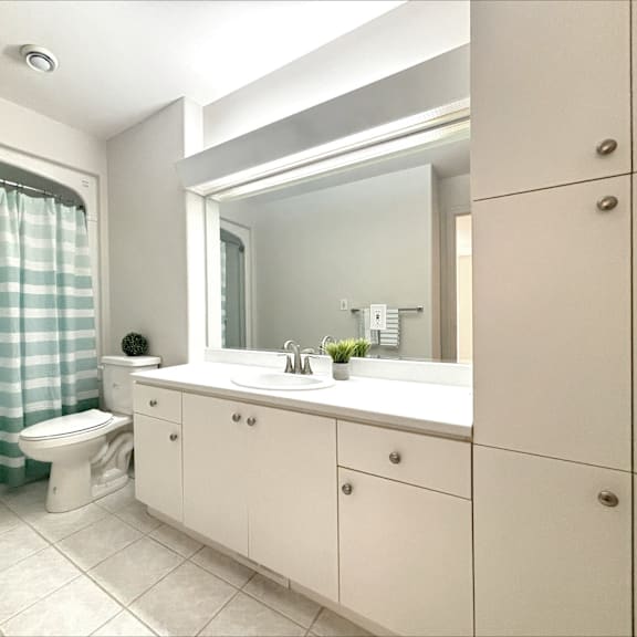 a bathroom with a toilet, sink, and shower curtain.