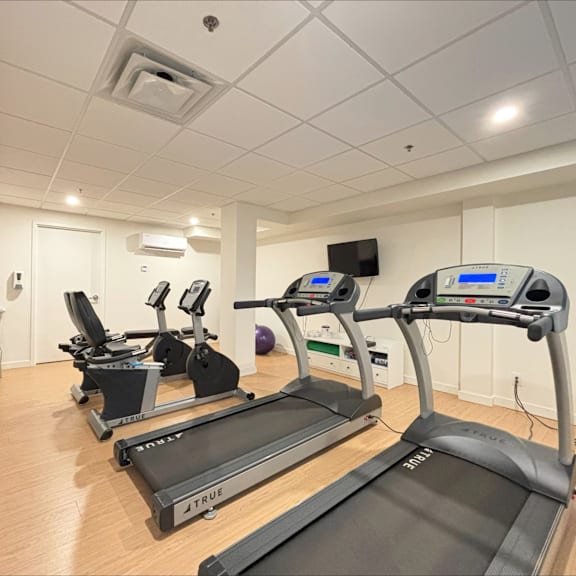 a gym with treadmills and exercise equipment.
