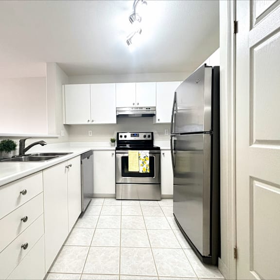 a modern kitchen with white cabinets and a stainless steel refrigerator.