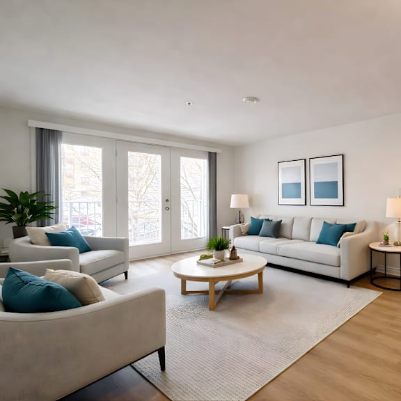 a living room with a white couch, a coffee table, and a plant.