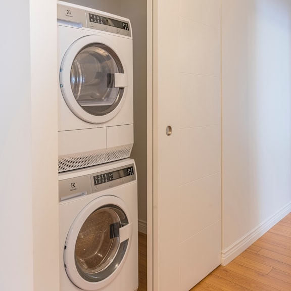 a white washing machine is placed in a small room.