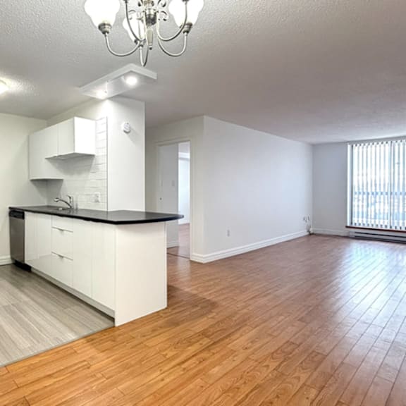 a spacious kitchen with white cabinets and a black countertop.