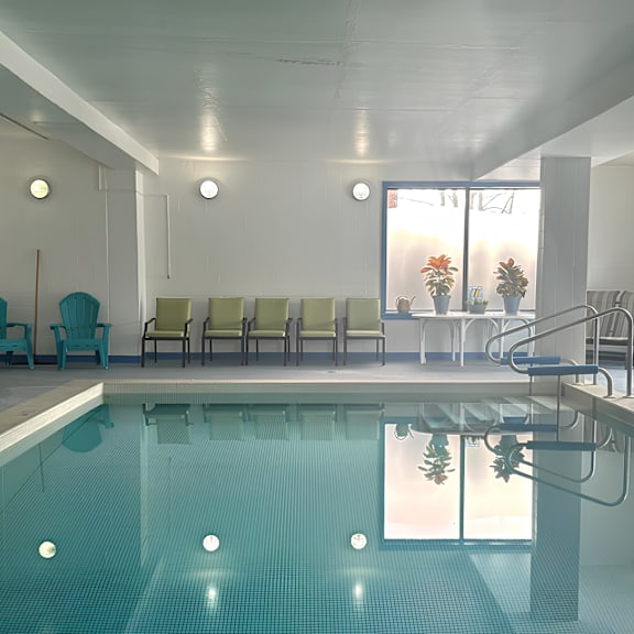 a large indoor swimming pool with a row of chairs and a staircase.