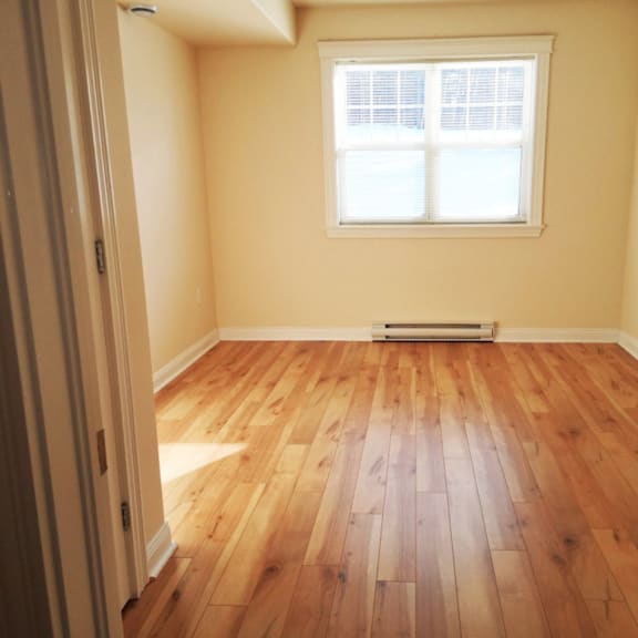 a room with wooden flooring and a window.