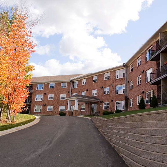 a large apartment complex with a driveway in front.