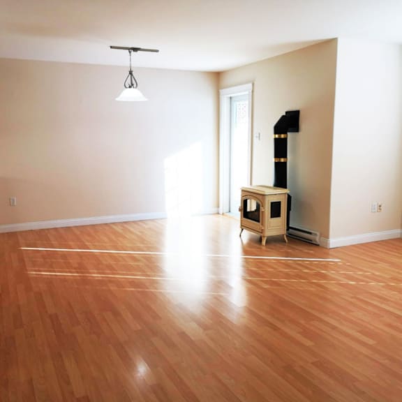 a room with wooden flooring and a wood-burning stove.