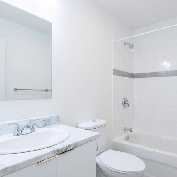 a white bathroom with a sink, toilet, and bathtub.