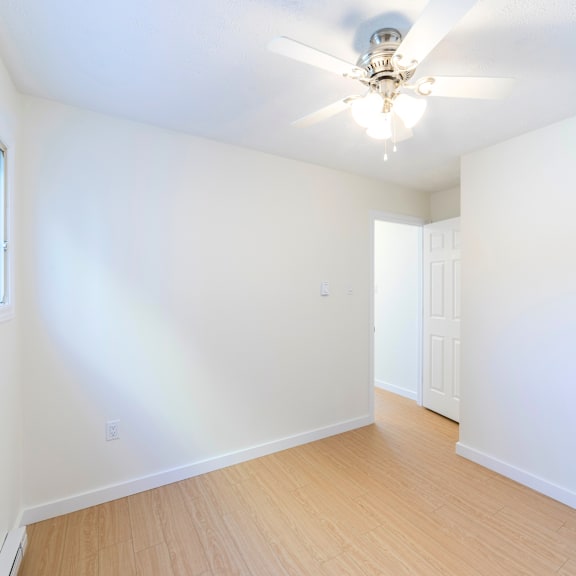 a room with a ceiling fan and two doors.