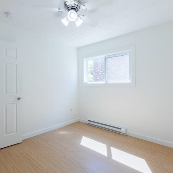 a room with a ceiling fan and a window.