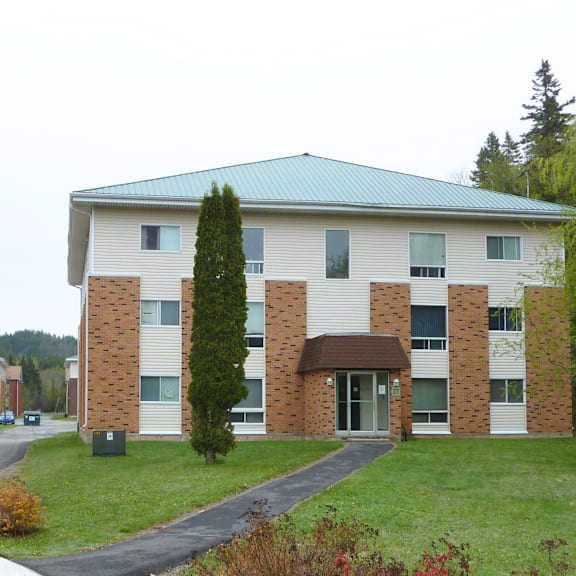 a large building with a green roof and a brick facade.