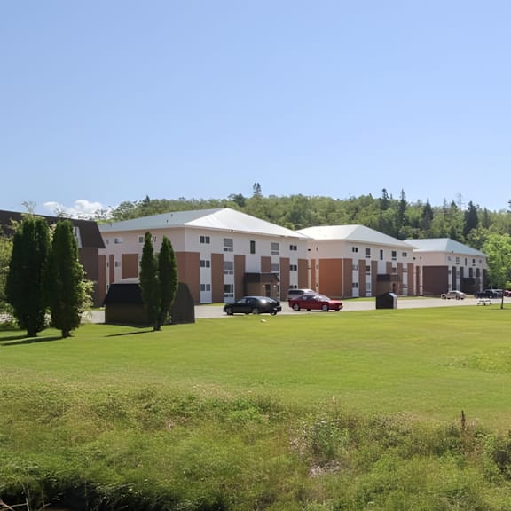 a large white building with a green lawn in front.