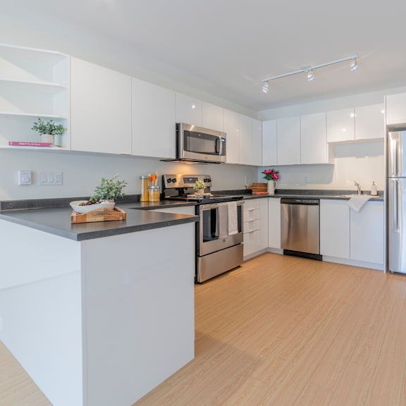 a modern kitchen with white cabinets and stainless steel appliances.