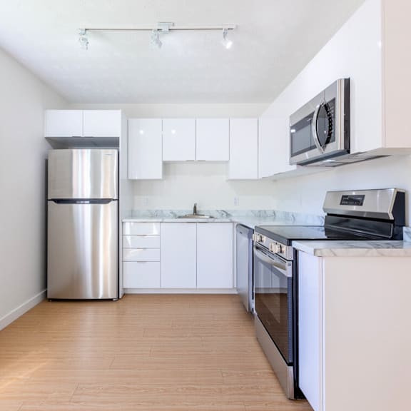 a kitchen with white cabinets and a stainless steel refrigerator.