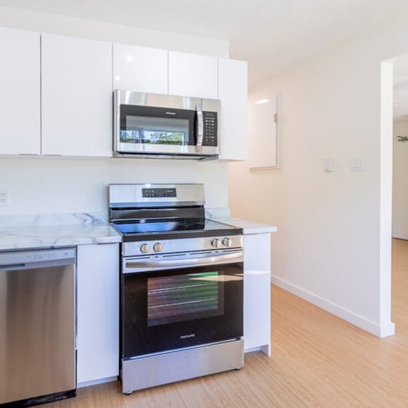 a modern kitchen with a stainless steel oven and microwave above it.