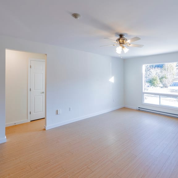 a room with a ceiling fan and a window.
