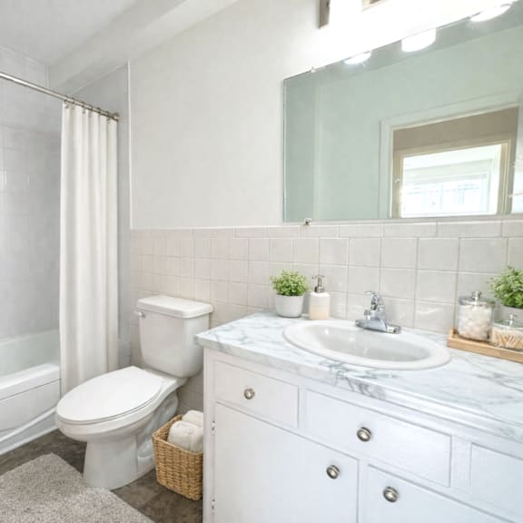 a white toilet sits next to a white sink in a bathroom.