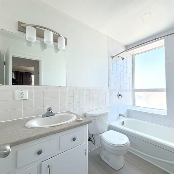 a white bathroom with a sink, toilet, and bathtub.