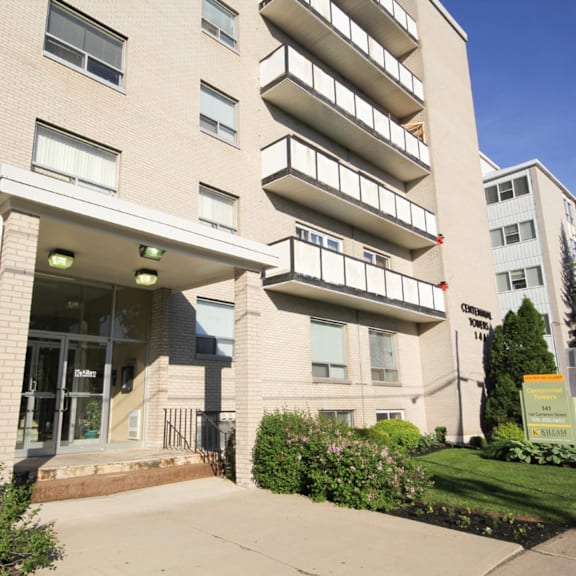 a large apartment building with a green lawn in front.