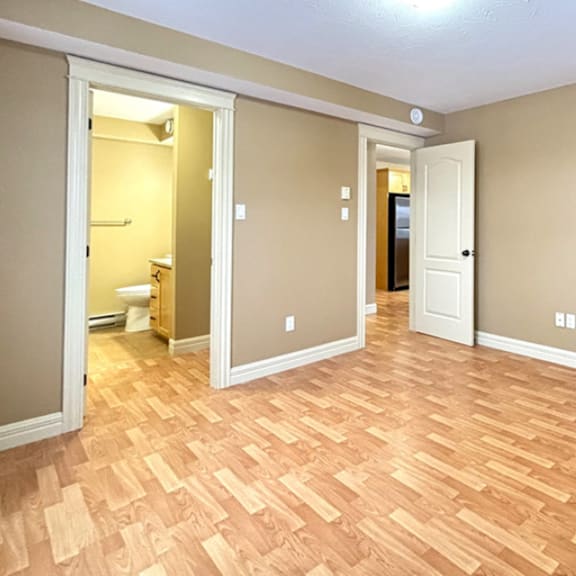 a room with wooden flooring and two doors.