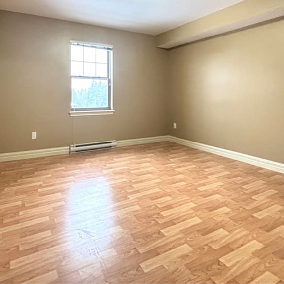 a room with wooden flooring and a window.