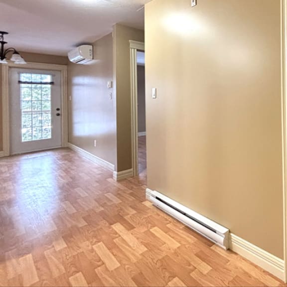 a room with a wooden floor and a wall-mounted air conditioner.