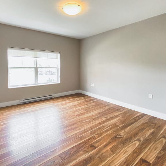a room with wooden flooring and a window.