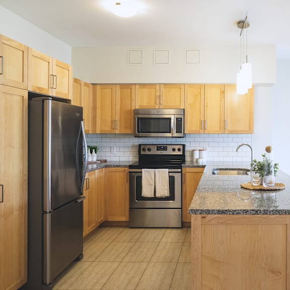 a kitchen with wooden cabinets and a black refrigerator.