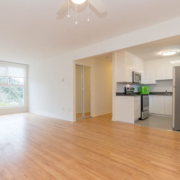 a kitchen with white cabinets and a wooden floor.