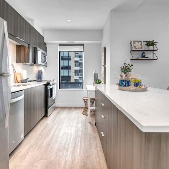 a modern kitchen with a large island and stainless steel appliances.