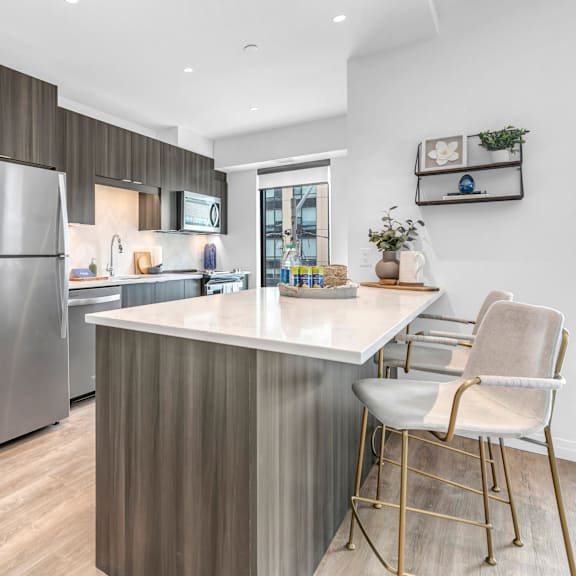 a modern kitchen with a stainless steel refrigerator and a white countertop.