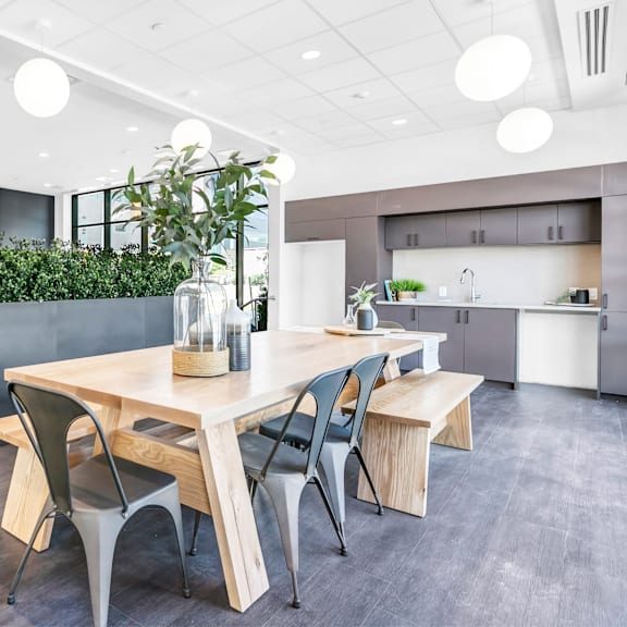 a modern dining area with a wooden table and chairs.