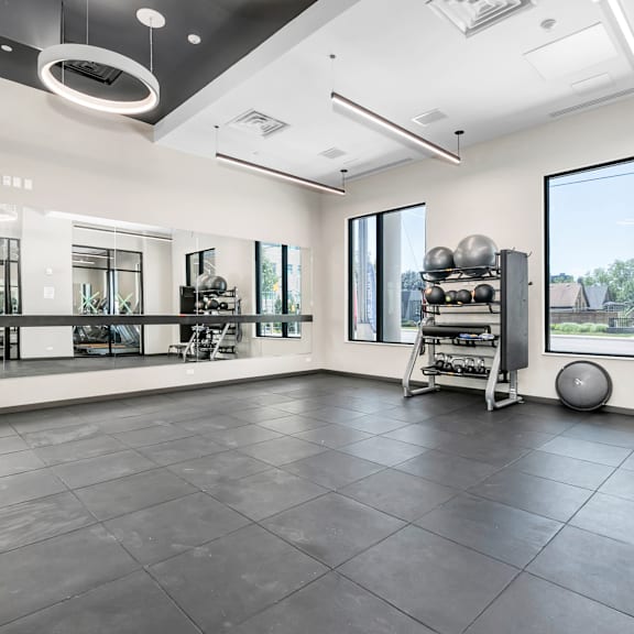 a spacious room with a black floor and white walls, equipped with gym equipment.