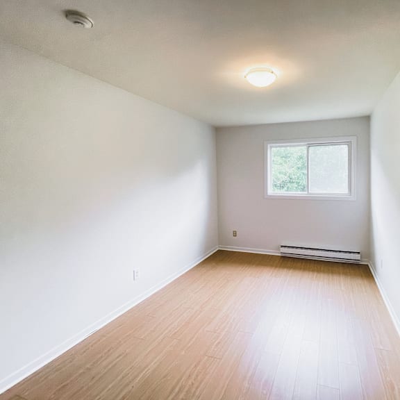 a room with a window and a radiator on the wall.