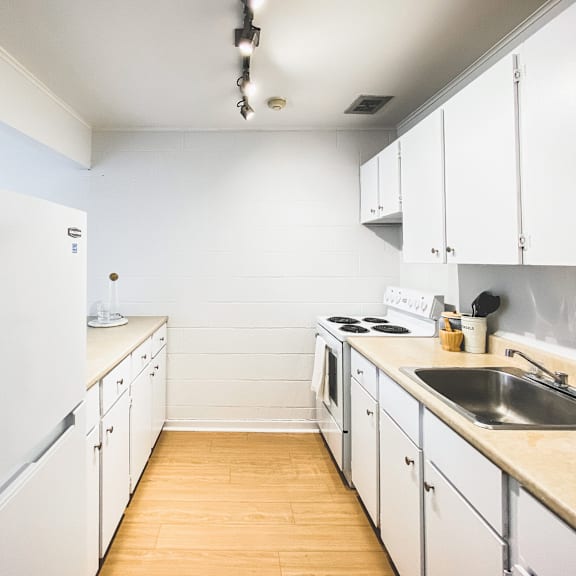 a kitchen with white cabinets and a white fridge.