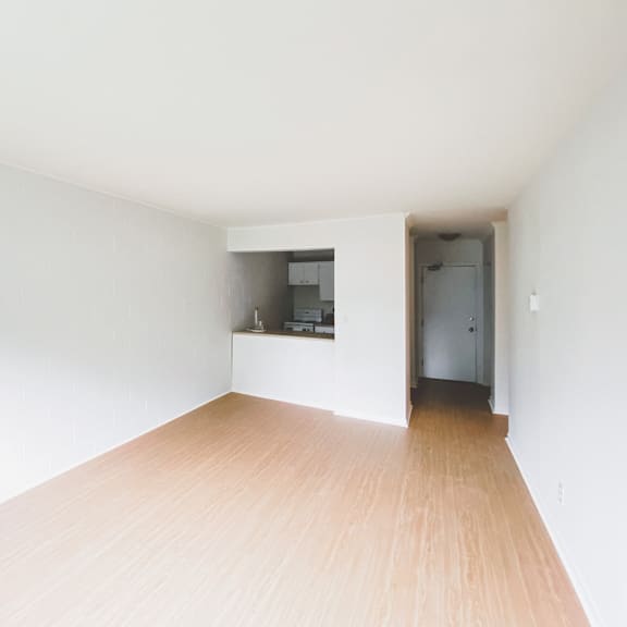 a room with a wooden floor and a small kitchenette.